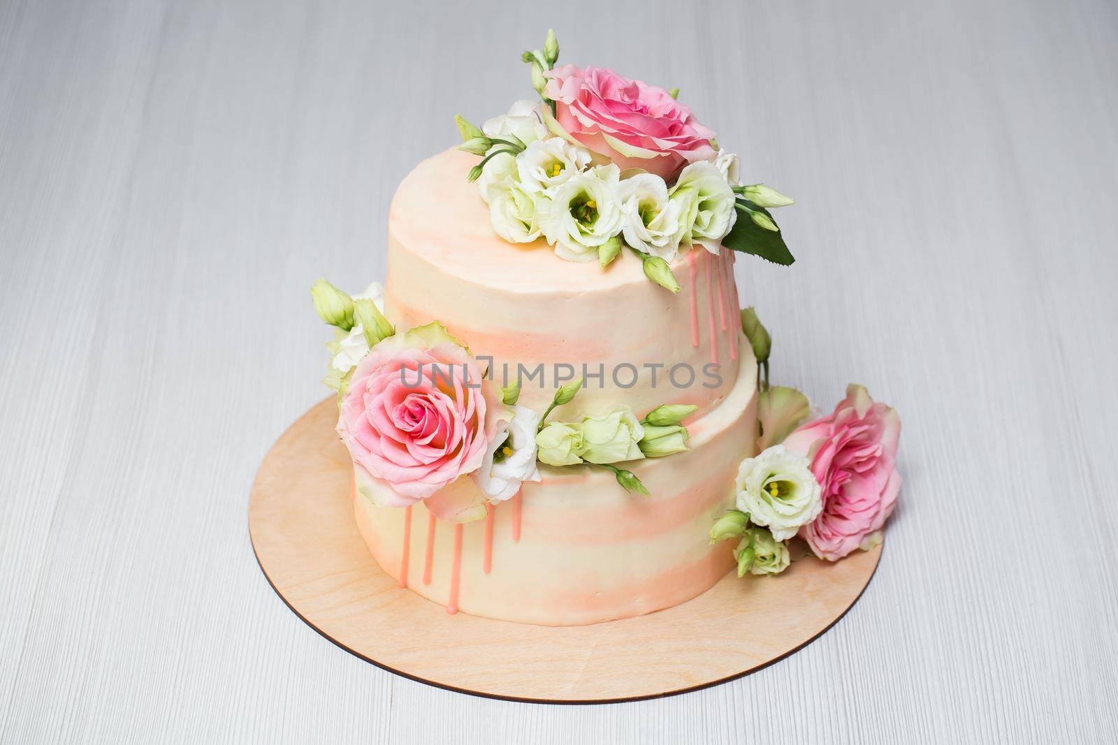 Tiered cake with fresh flowers and macaroons