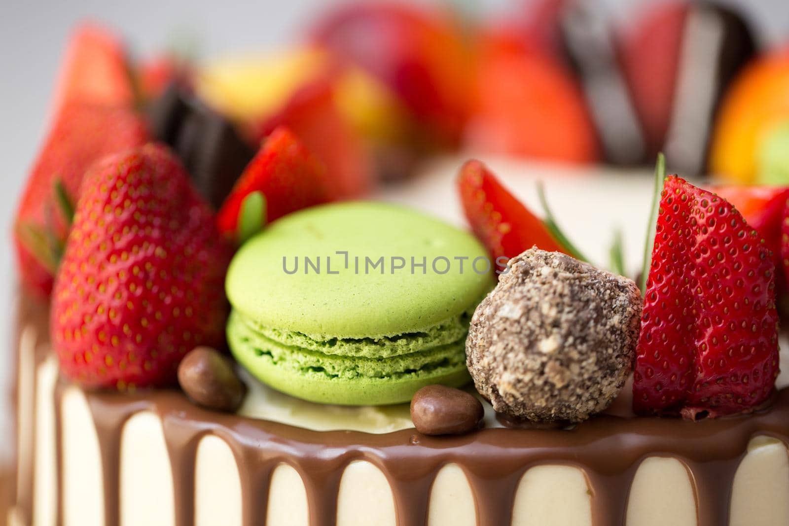 Cake with chocolate drips, strawberries, peaches macaroons rosemary