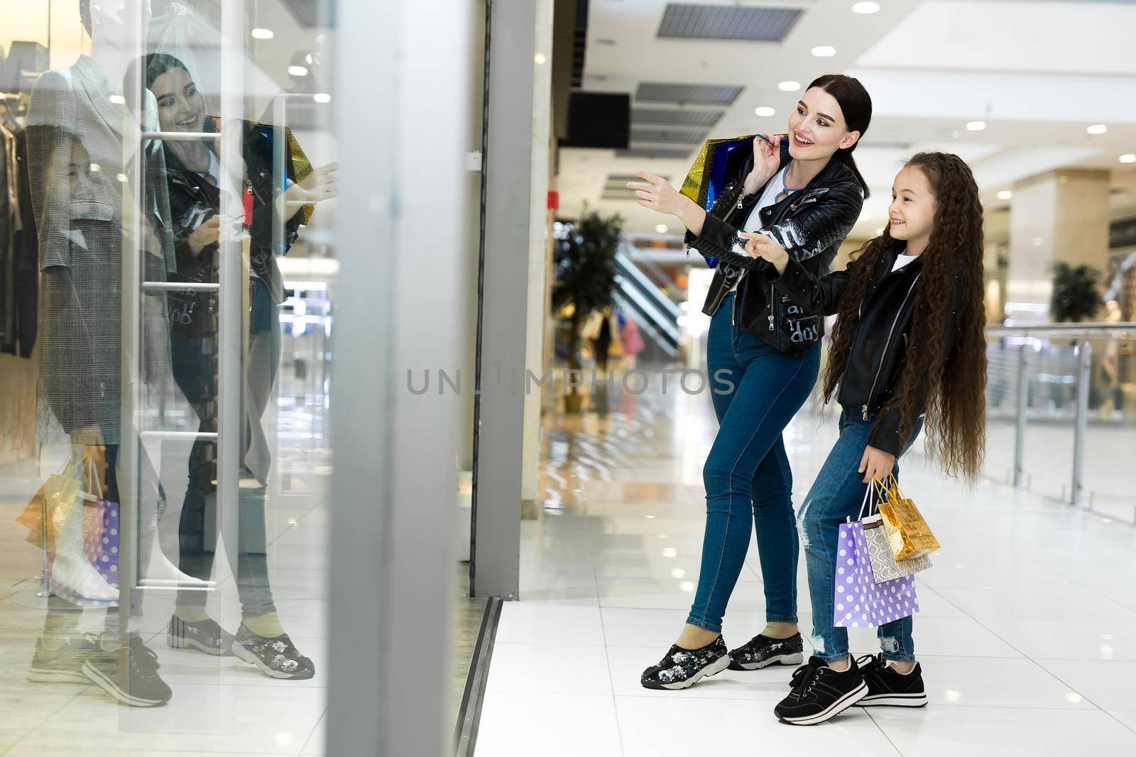 Beautiful mom and daughter smiling while shopping at the mall
