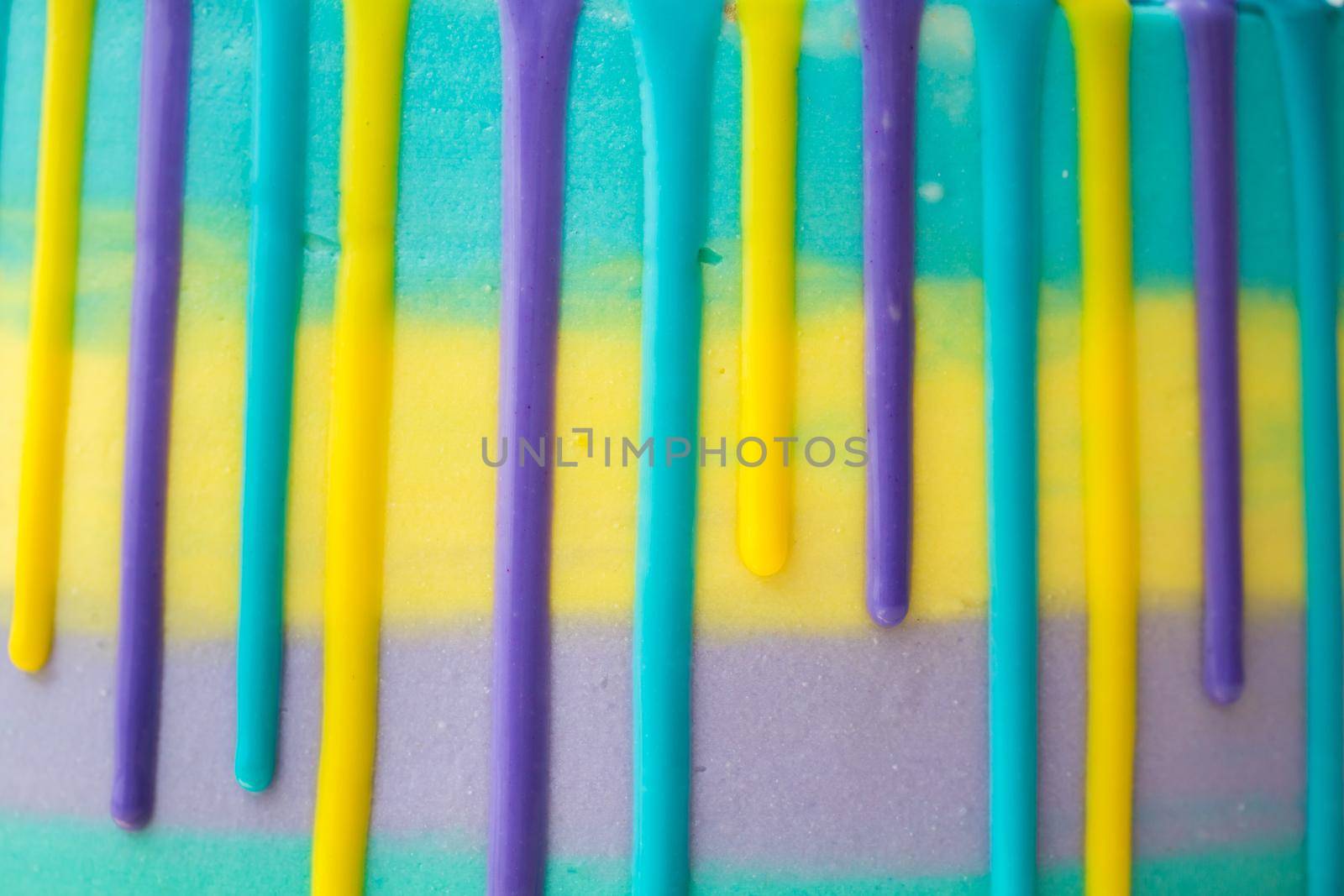 Chocolate drops on a striped cake close-up.