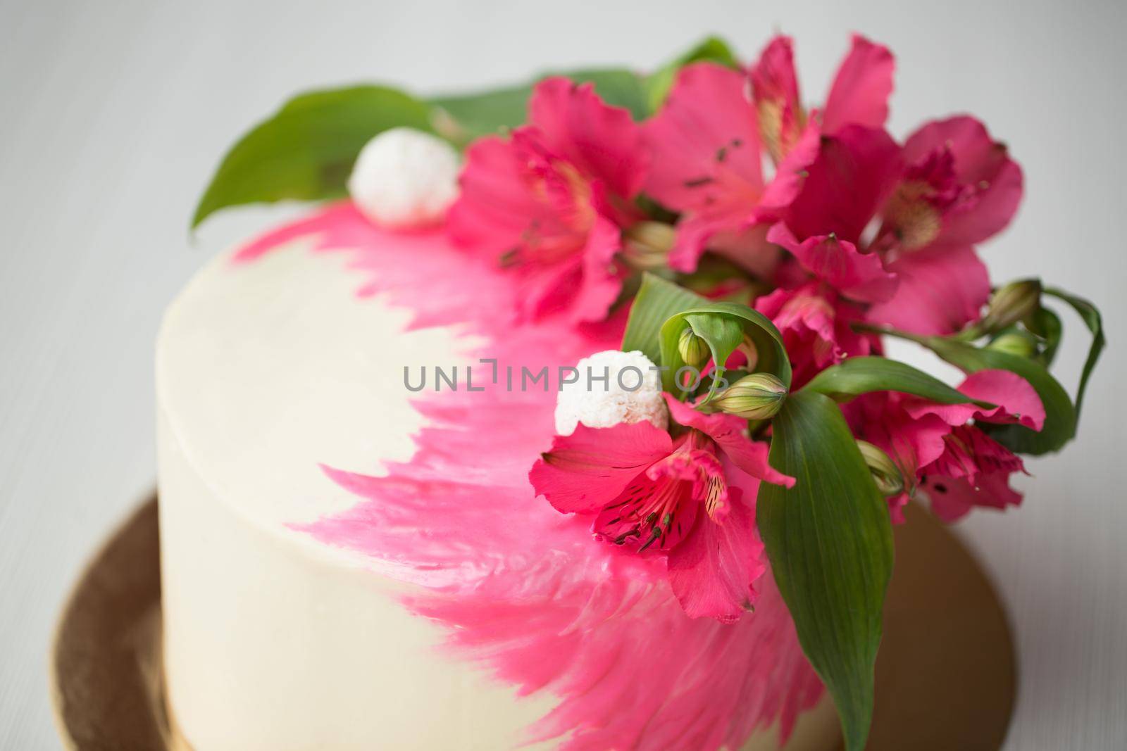 Cake with pink chocolate decor and flowers.