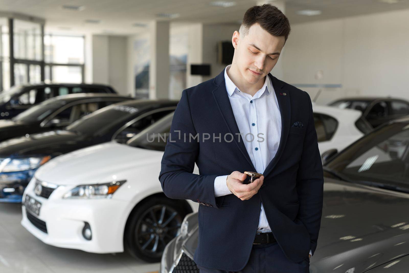 Handsome man choosing a car in a show room