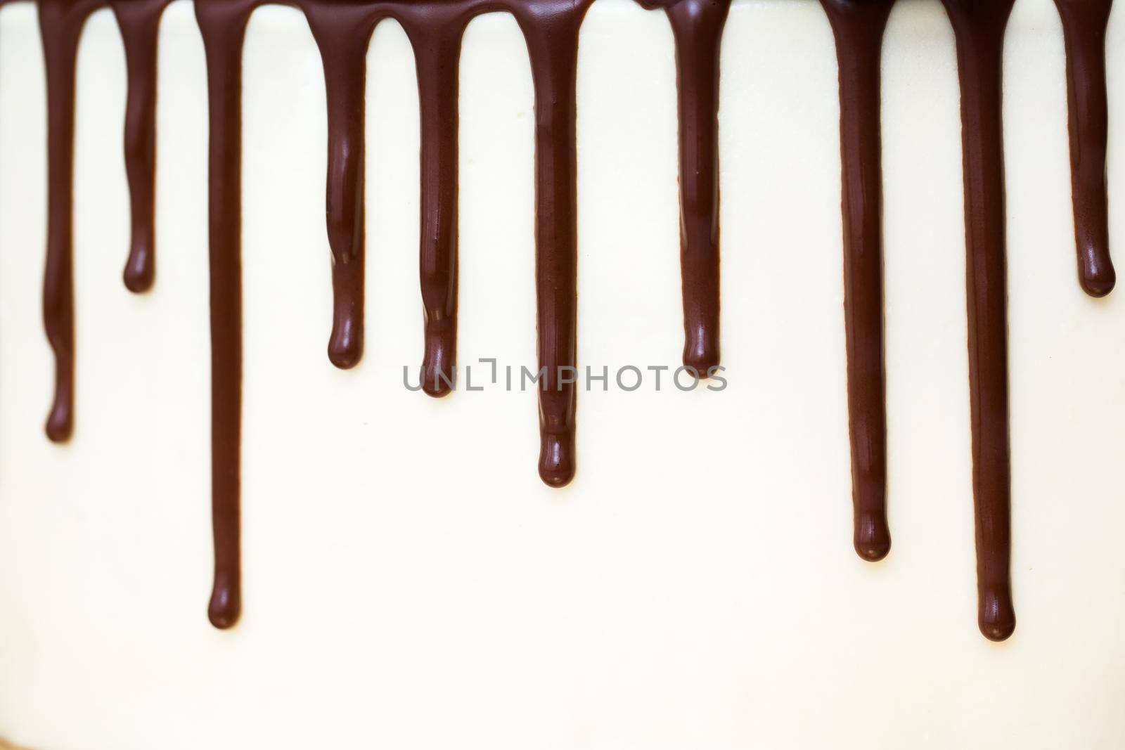 Chocolate drips on the background of white cream. by StudioPeace