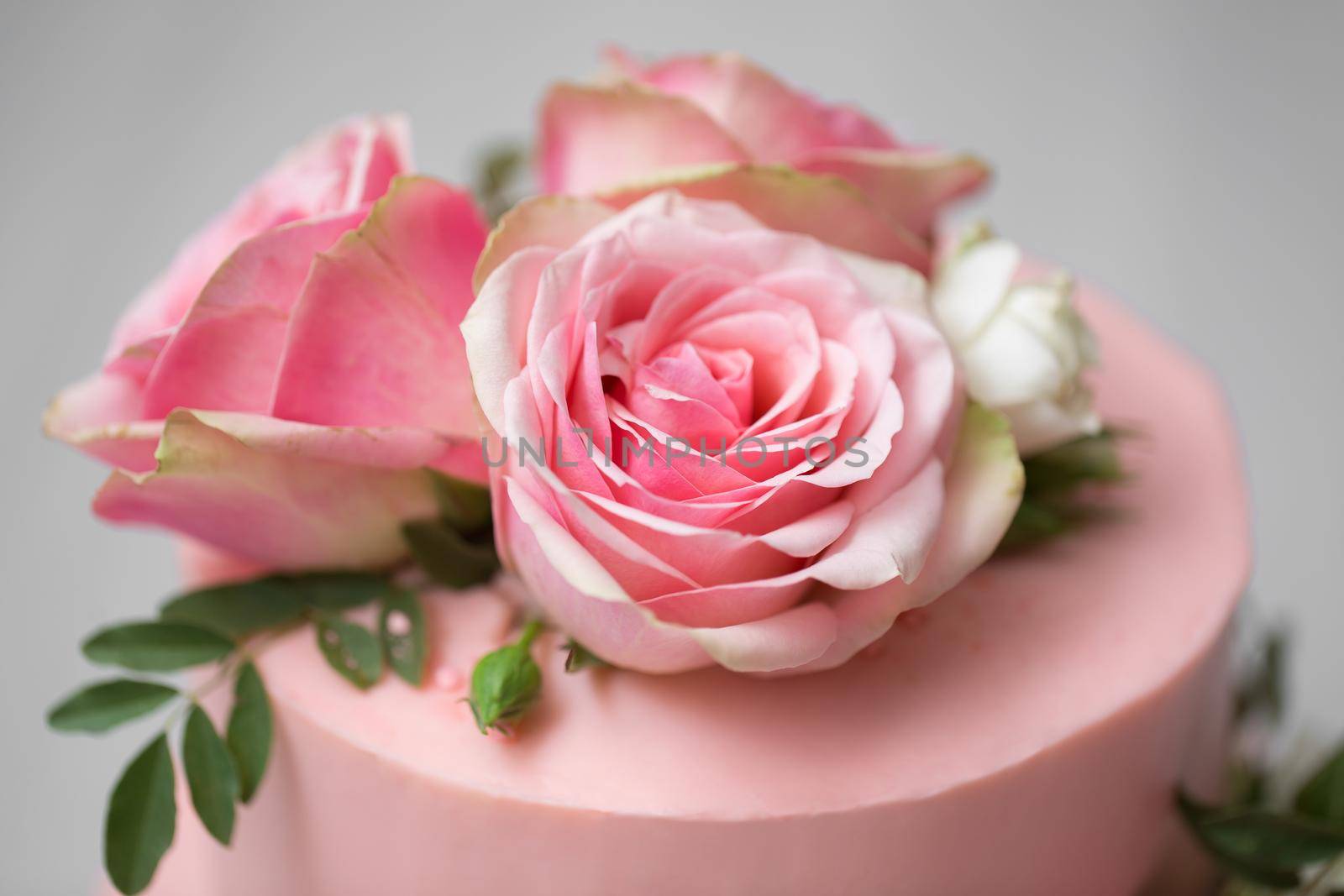 Delicate pink wedding cake with fresh flowers.