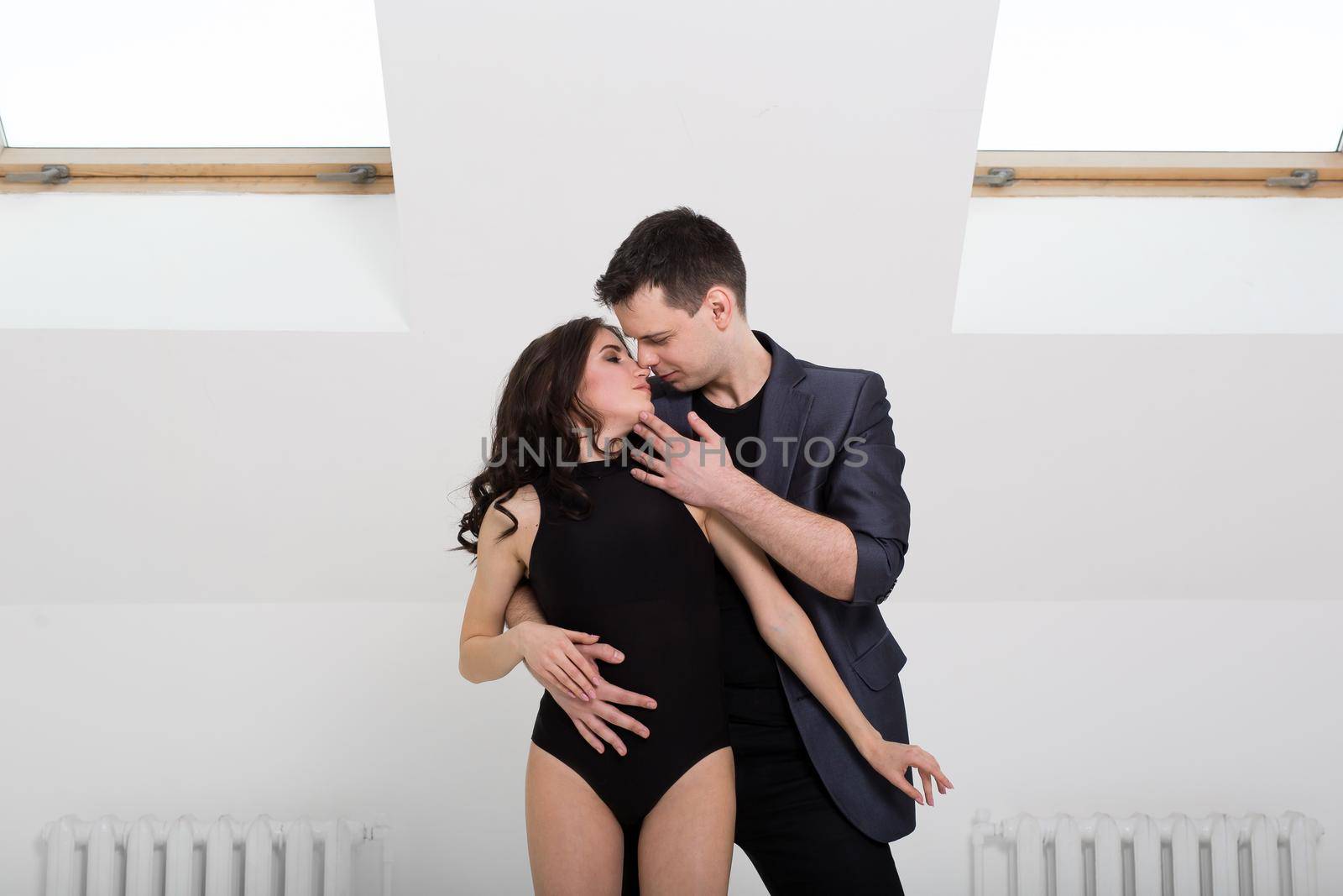 beautiful couple dancing bachata on white background in studio. by StudioPeace