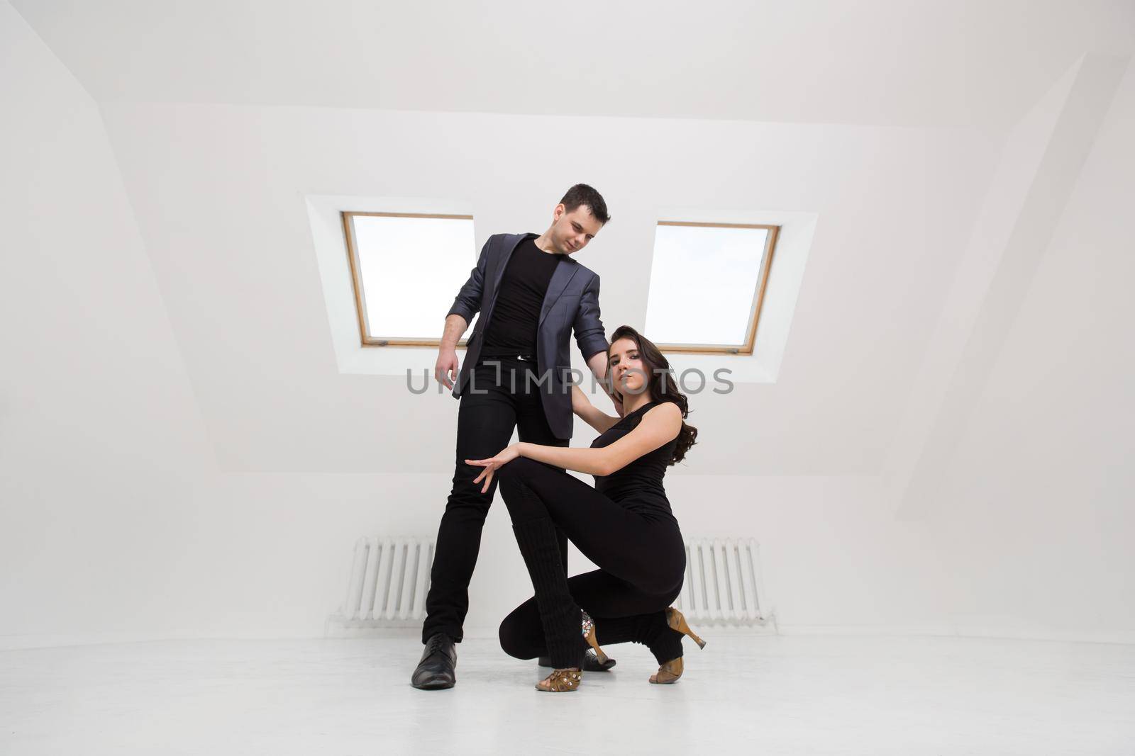 beautiful couple dancing bachata on white background in studio