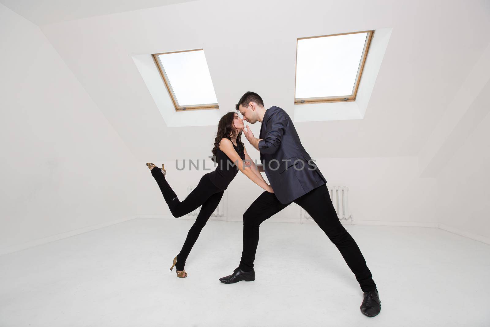 beautiful couple dancing bachata on white background in studio. by StudioPeace