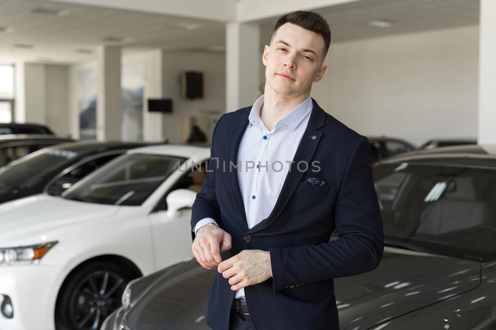 Handsome man choosing a car in a show room