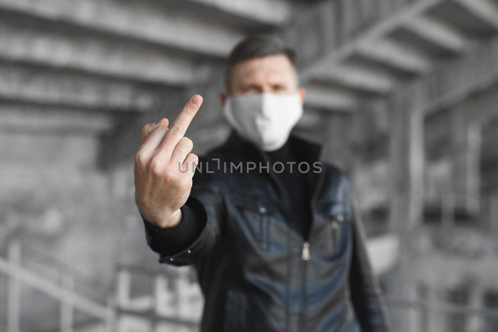 Go away from here. Young angry man with surgical medical mask showing fuck sign at camera. Coronavirus. covid 19. by StudioPeace