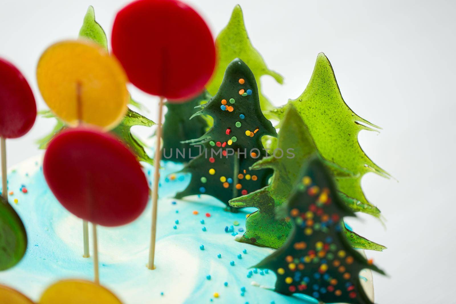 Lollipops are round and shaped like a Christmas tree on a cake.