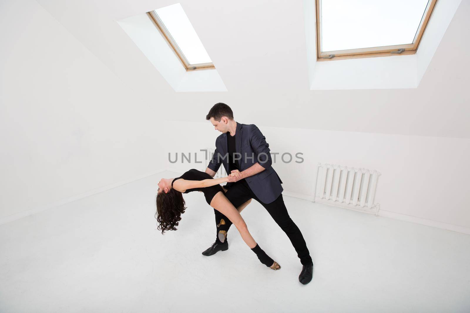 beautiful couple dancing bachata on white background in studio