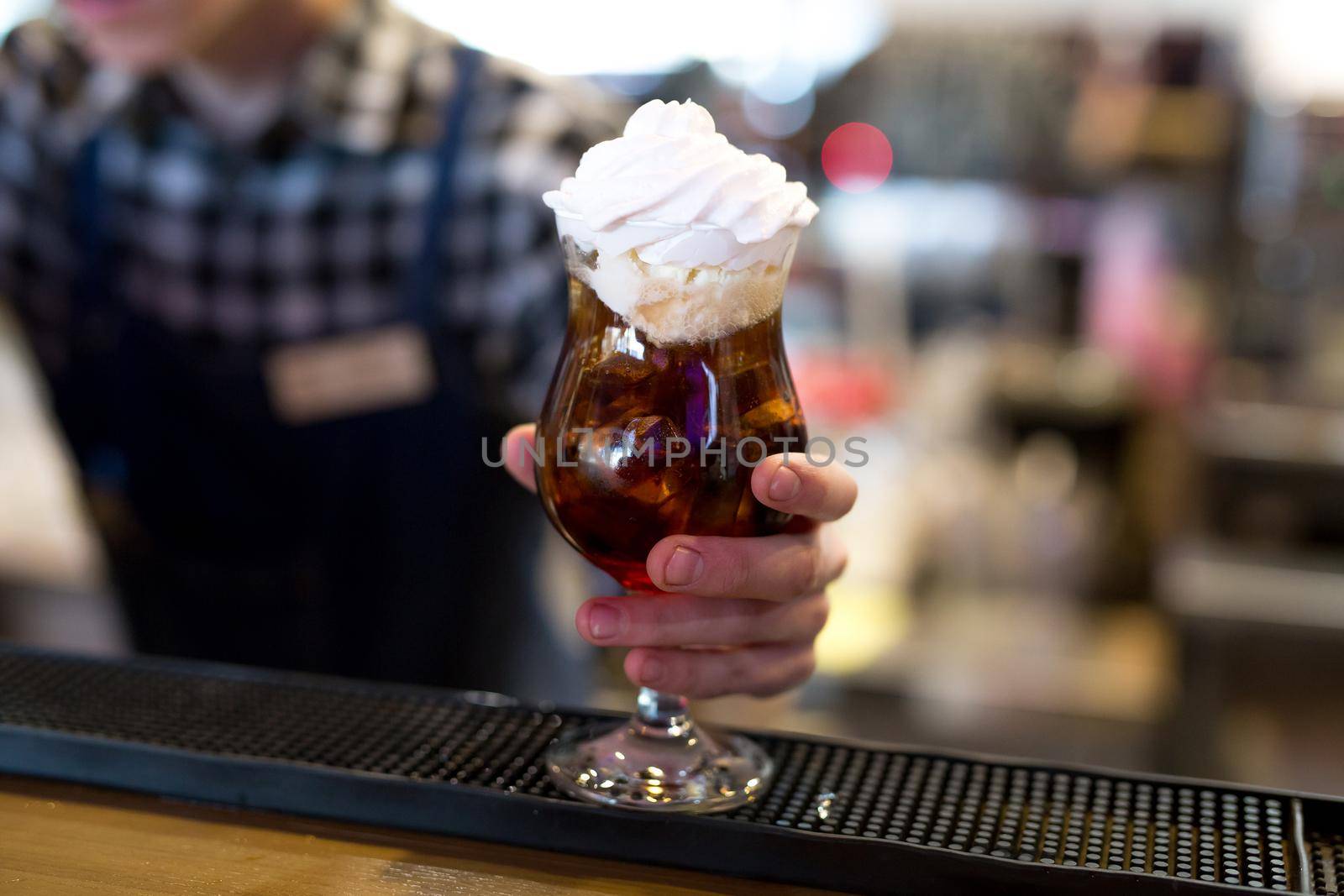 Cocktail with Coca-Cola, ice, ice cream and whipped cream close-up.