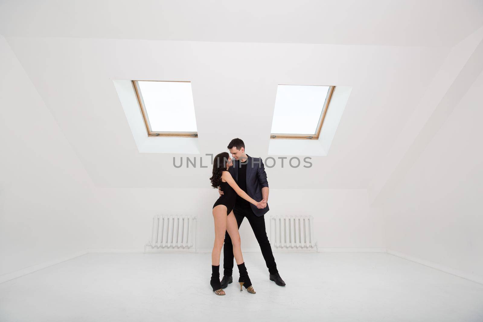 beautiful couple dancing bachata on white background in studio. by StudioPeace