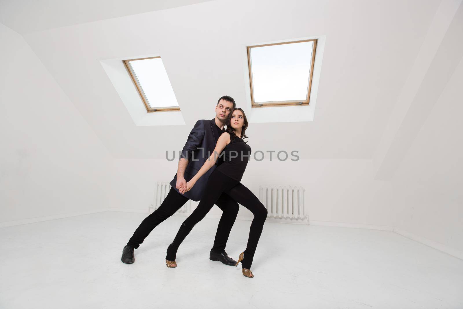 beautiful couple dancing bachata on white background in studio. by StudioPeace