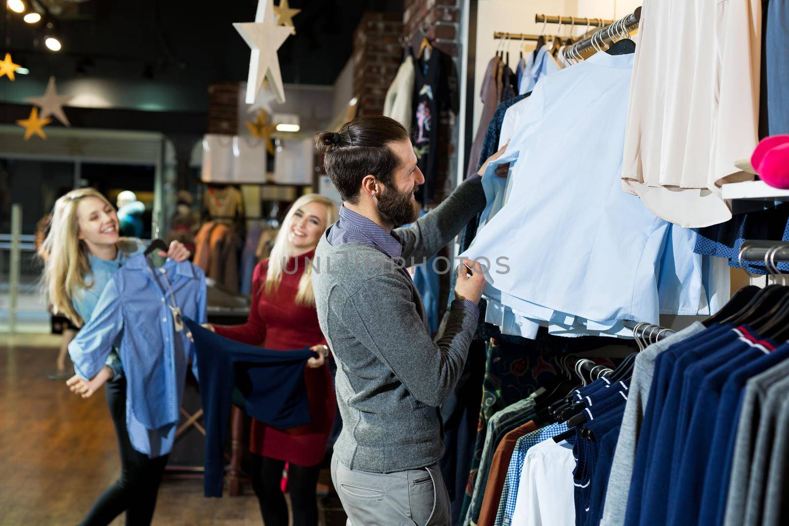 Man chooses a shirt in the store. Sale, shopping, fashion, style and people concept. by StudioPeace