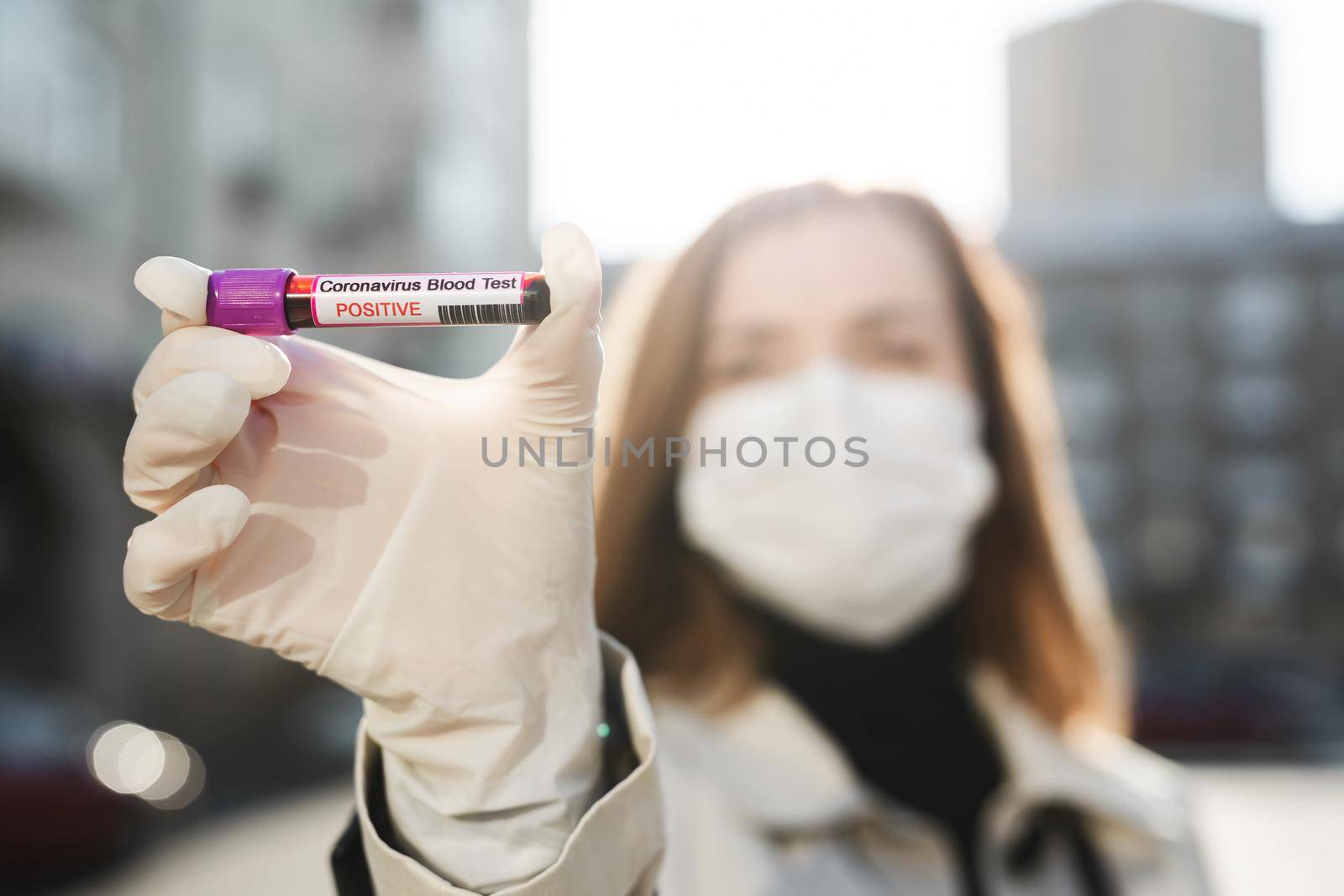 Wonan's hands holding a test tube with a blood sample for research new rapidly spreading Coronavirus Covid-19 by StudioPeace