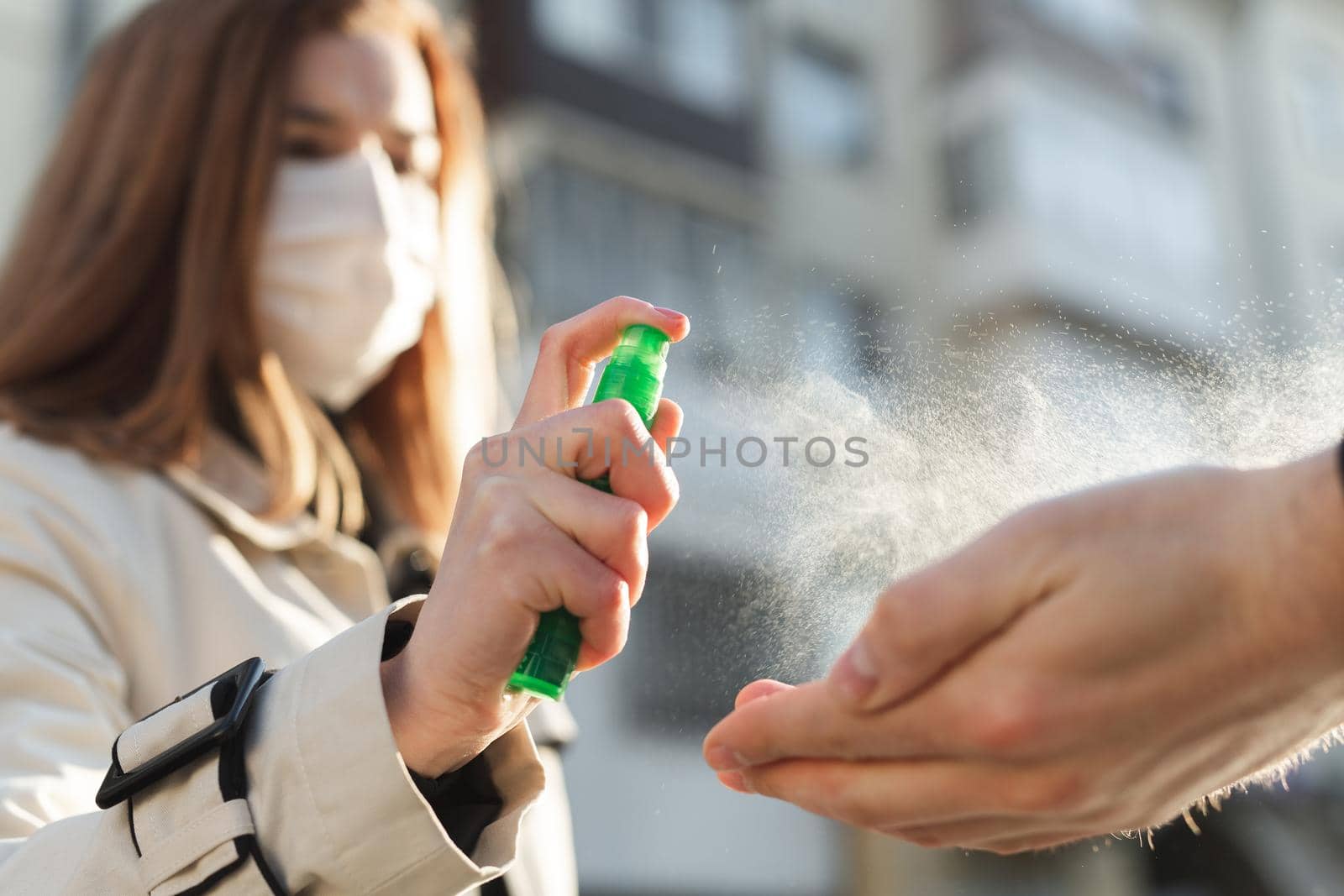 People who use alcohol-based antiseptic gel and wear a preventive mask prevent infection with the Covid-19 coronavirus outbreak, a woman washes a man's hands with hand sanitizer.