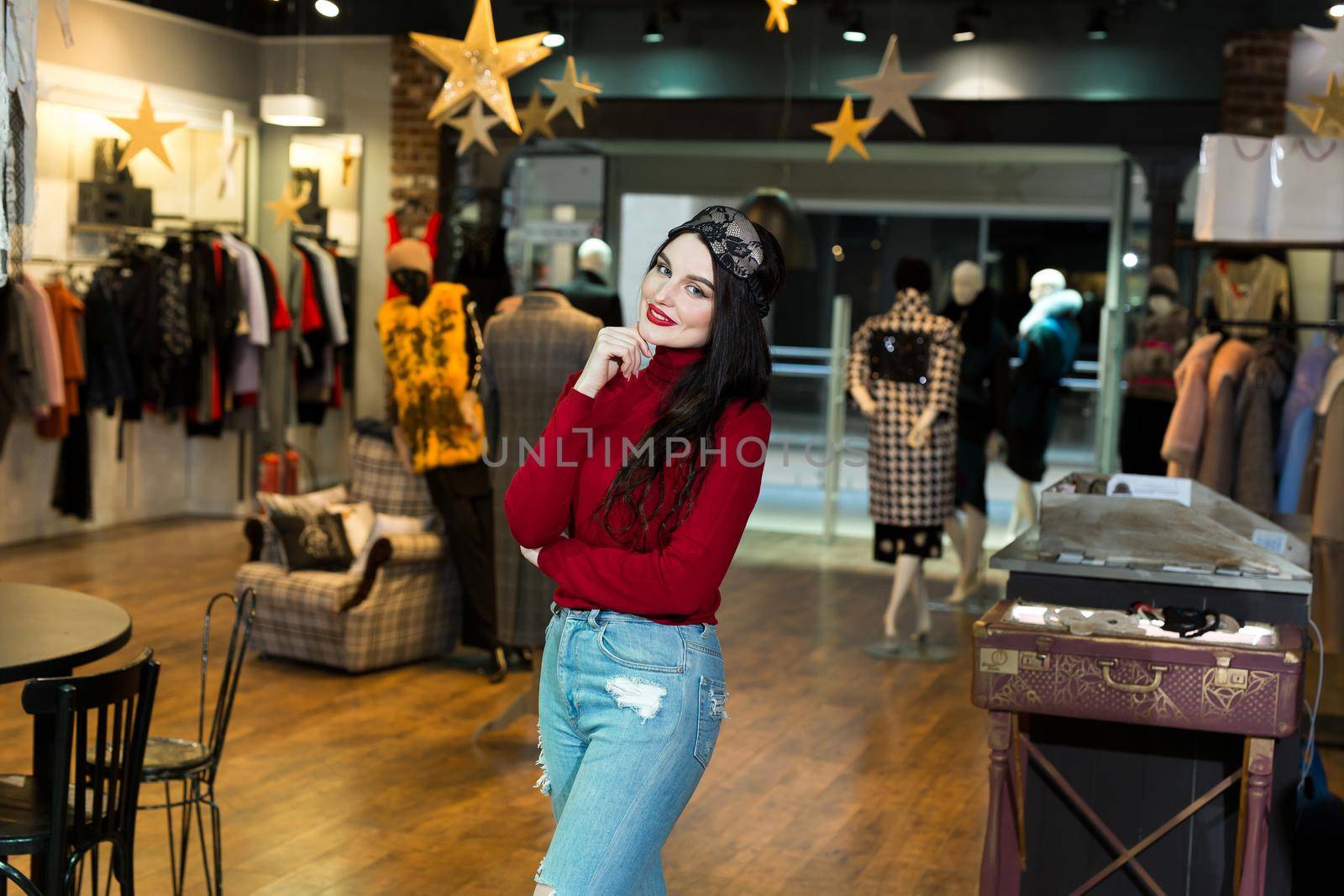 Portrait of model woman in sleeping mask. Pretty young woman happily smiling and posing in clothing store