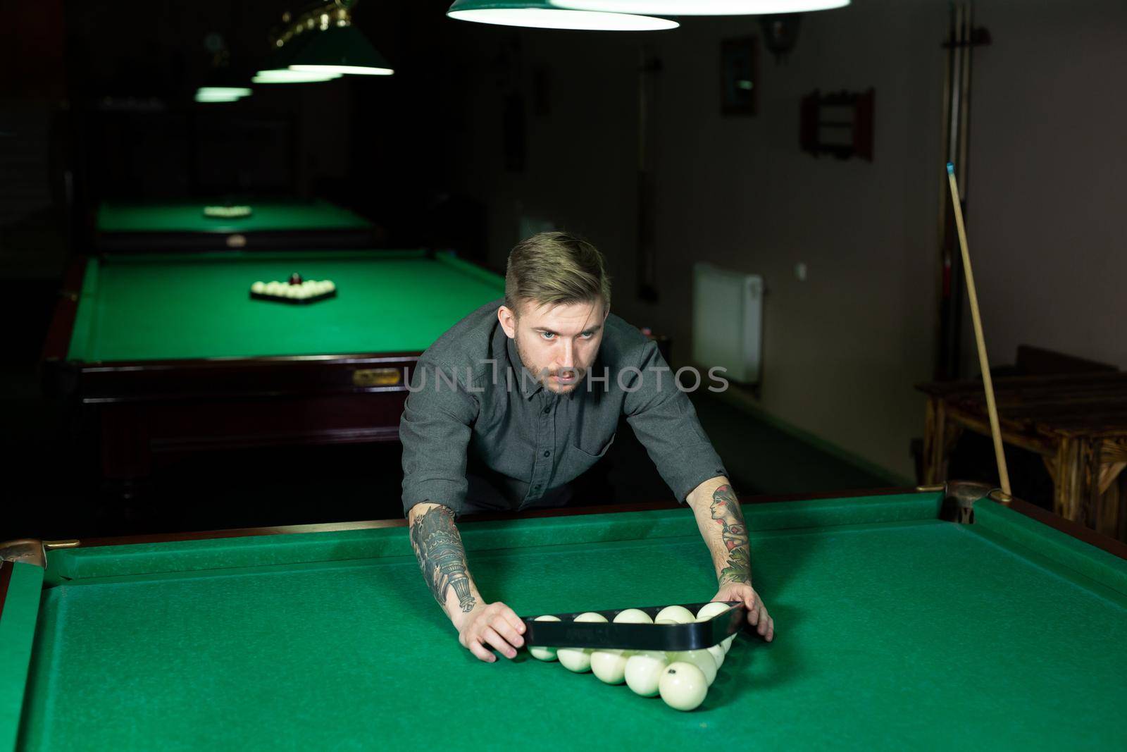 Triangle of billiard balls. A man getting ready to start a game of billiards