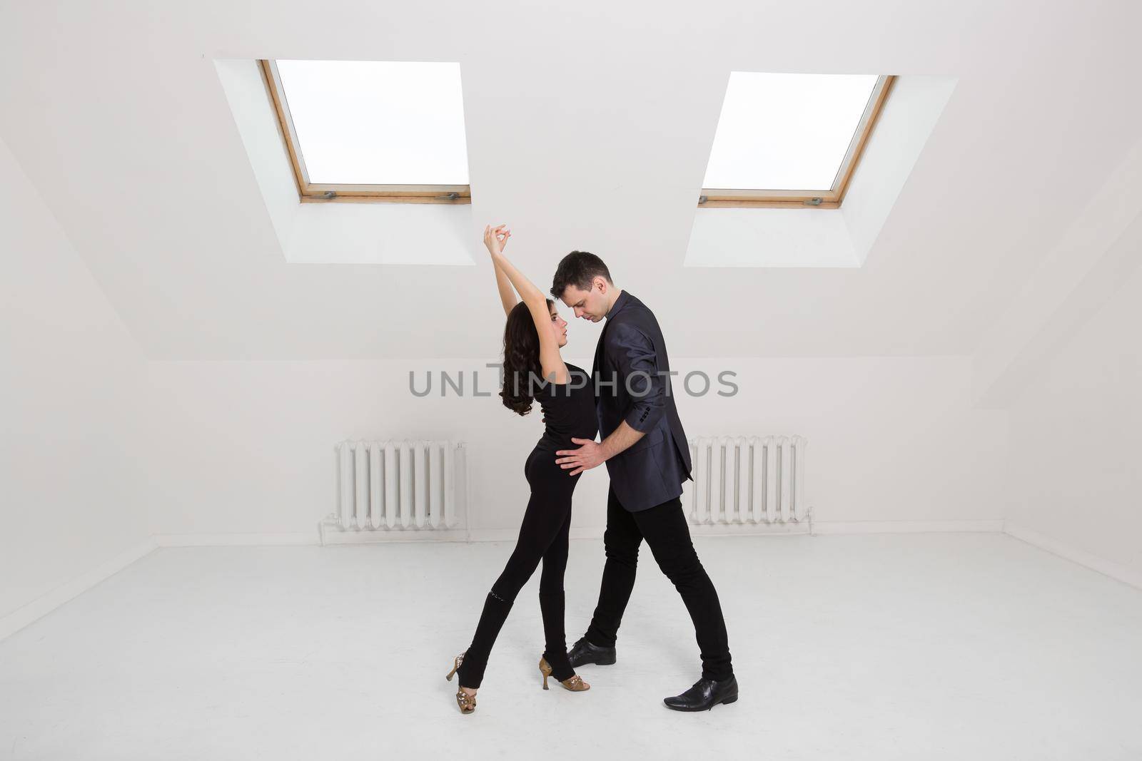 beautiful couple dancing bachata on white background in studio