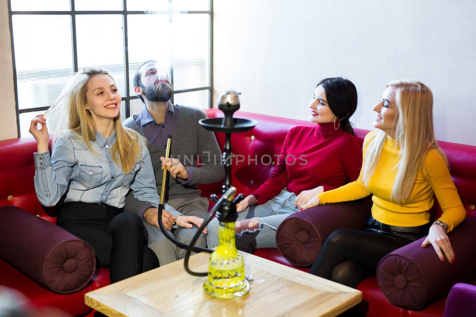 Friends smoke hookah and have fun, laugh by StudioPeace