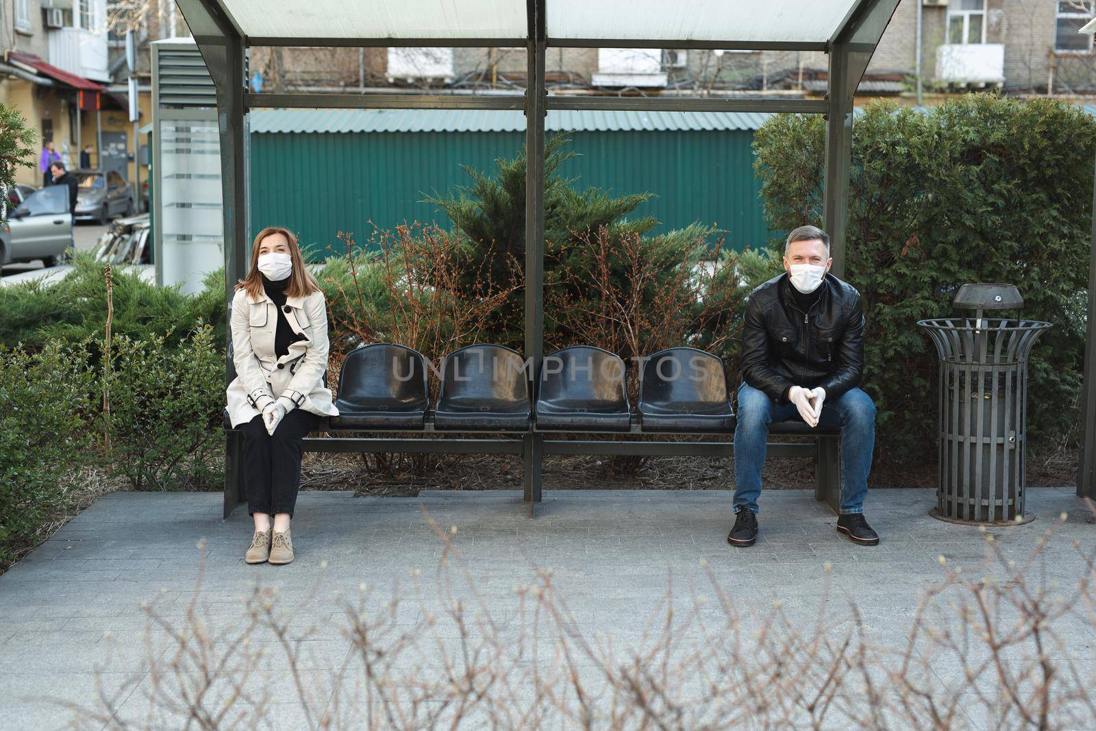 Distance between a man and a woman at a bus stop during a coronavirus epidemic. Covid 19 by StudioPeace