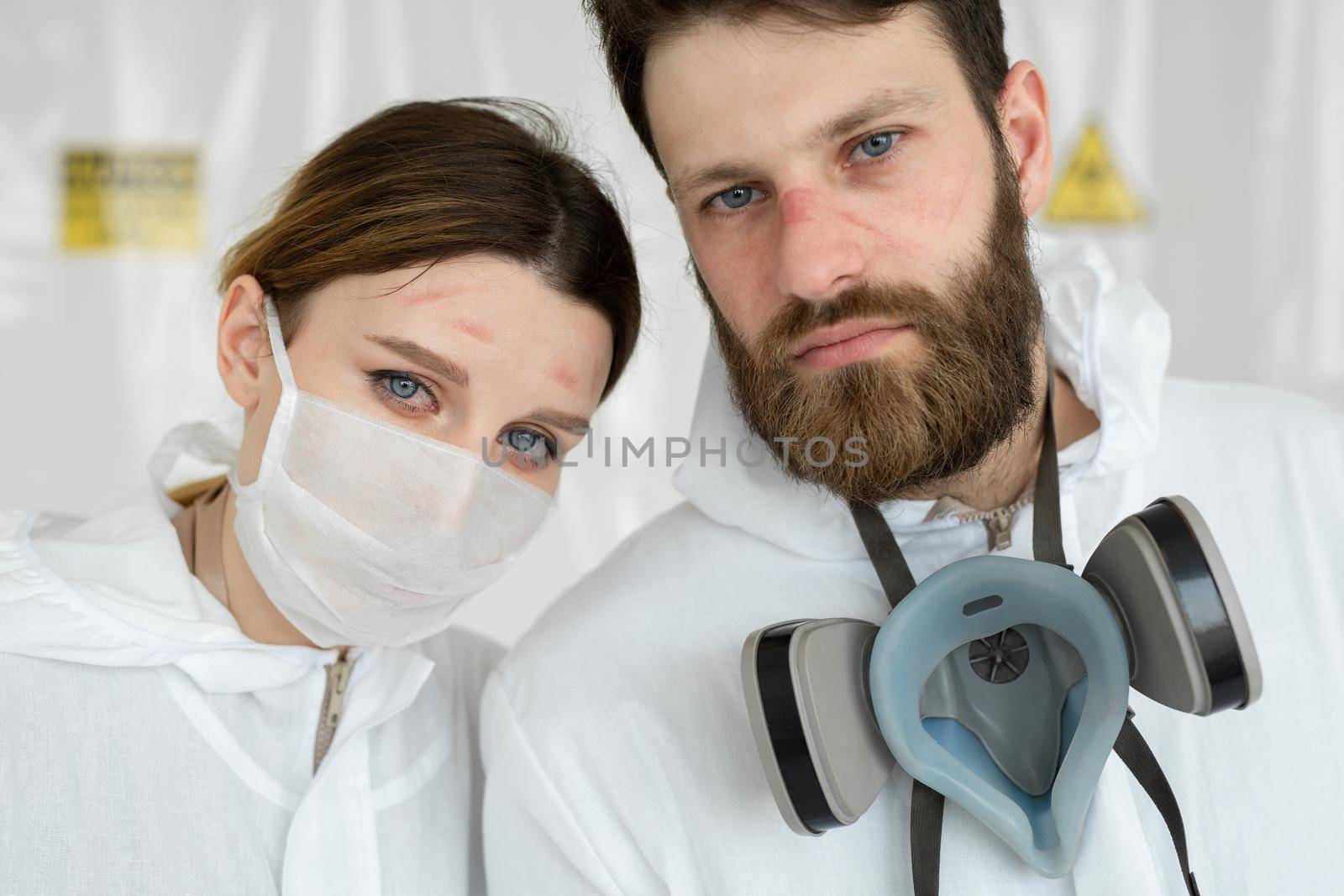 Exhausted doctors or nurses taking of protective mask uniform. Coronavirus Covid-19 outbrek. Mental state of medical professional. Overworked health workers with tears in his eyes.