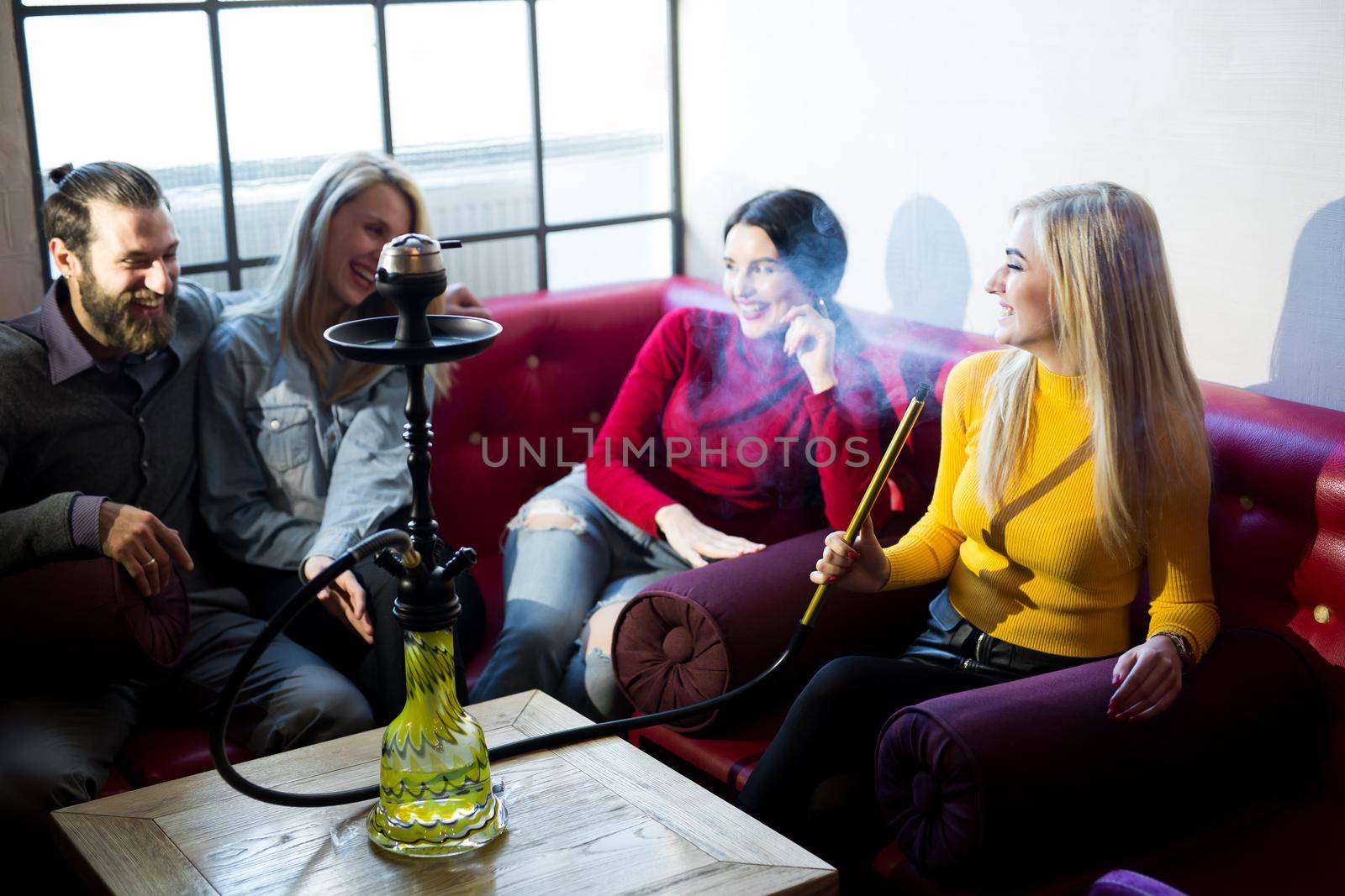 Friends smoke hookah and have fun, laugh by StudioPeace