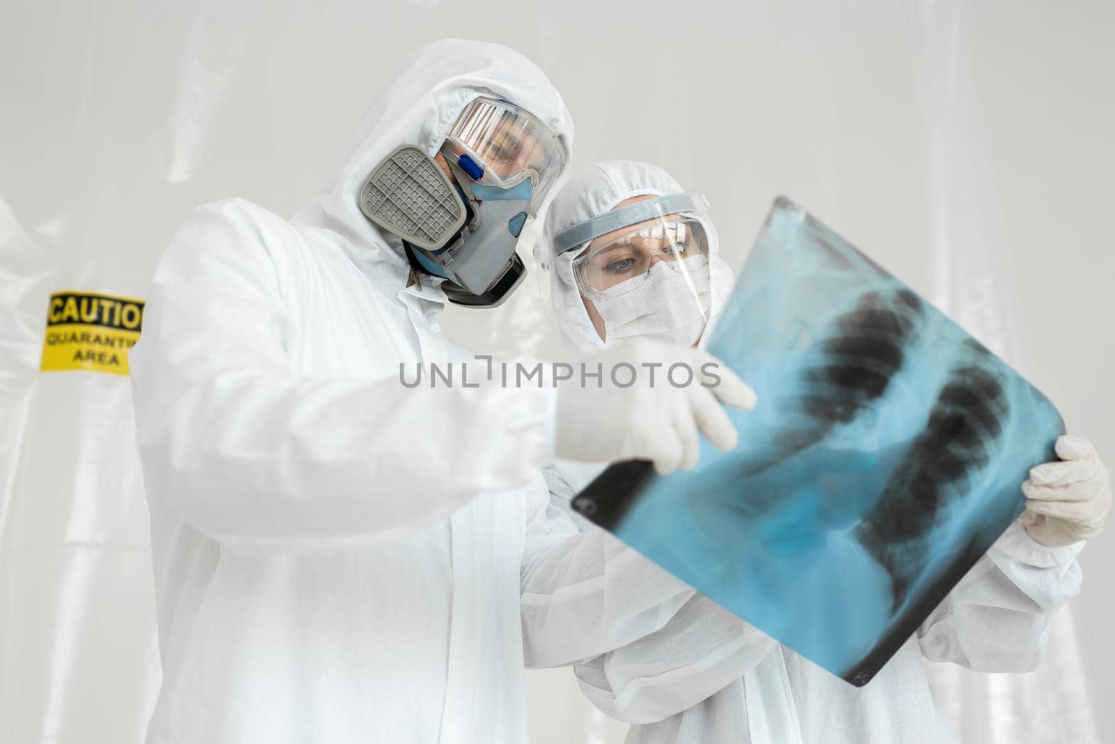 Doctors Epidemiologists examine x-ray for pneumonia of a Covid-19 patient. Coronavirus concept. by StudioPeace