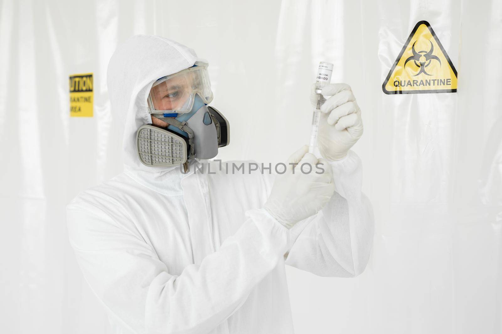 Doctor holds COVID 19 Coronavirus vaccine in his hand, Vaccine and syringe injection It use for prevention, immunization and treatment. In a Secure Laboratory Scientists in a Coverall Conducting a Research Vaccine COVID-19. by StudioPeace