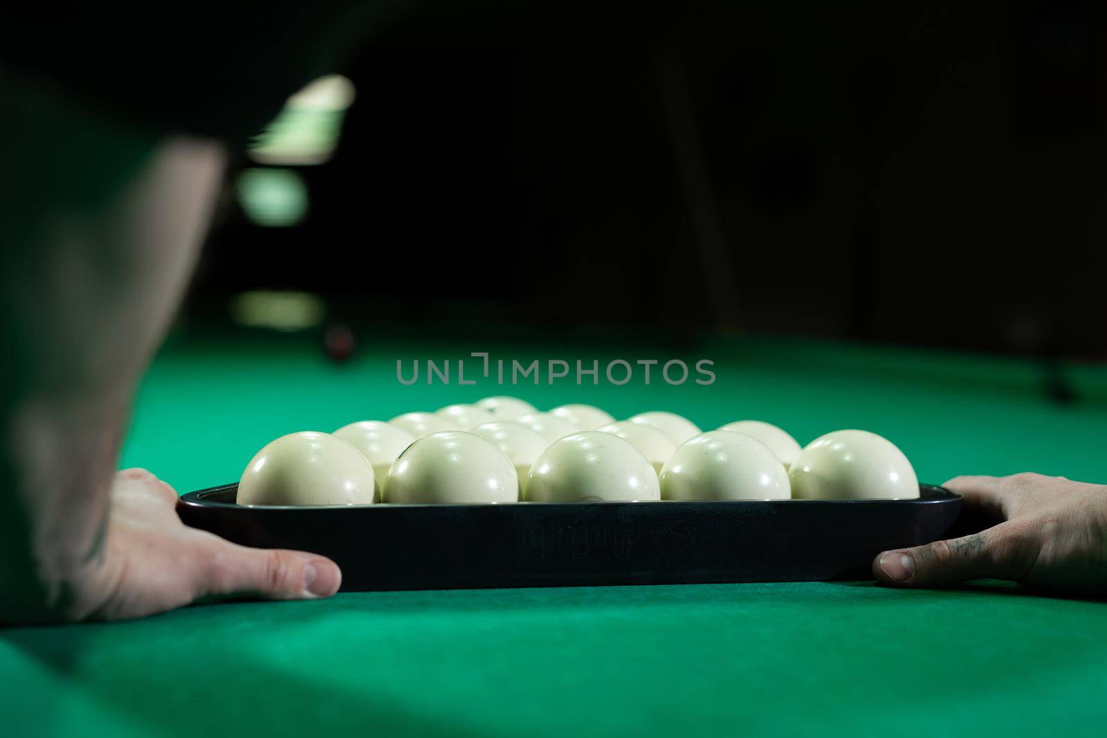 Triangle of billiard balls. A man getting ready to start a game of billiards