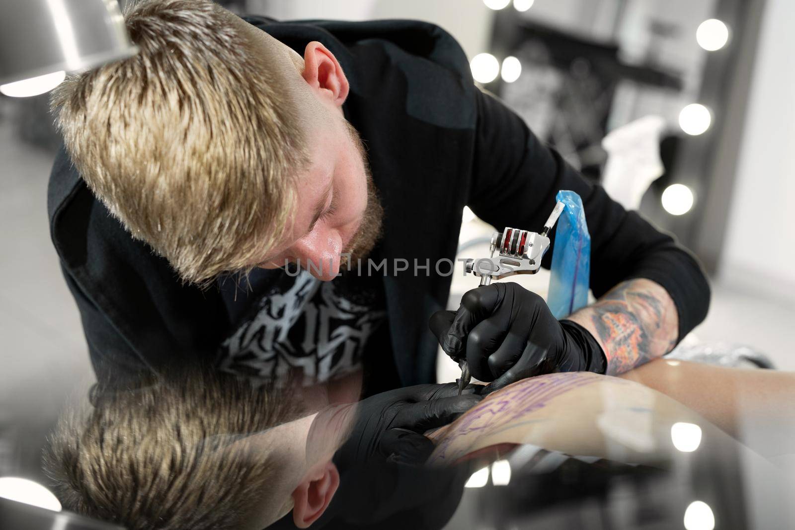 Close-up of tattooist draws on girl's hip. by StudioPeace