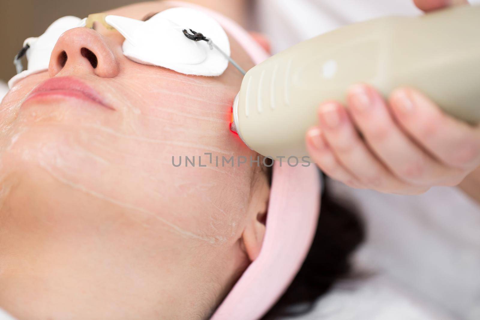 Close-up cosmetologist makes radio wave lifting for a young girl in a modern equipped Spa salon