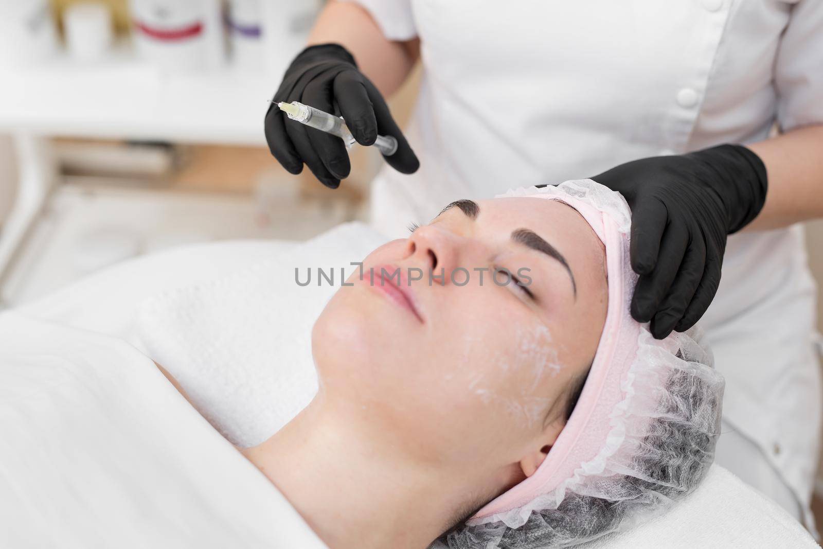 Woman face cosmetology treatment. Biorevitalization skin therapy. Injecting in medical salon. The procedure of biorevitalization in the area of eyes with a preparation with hyaluronic acid by StudioPeace