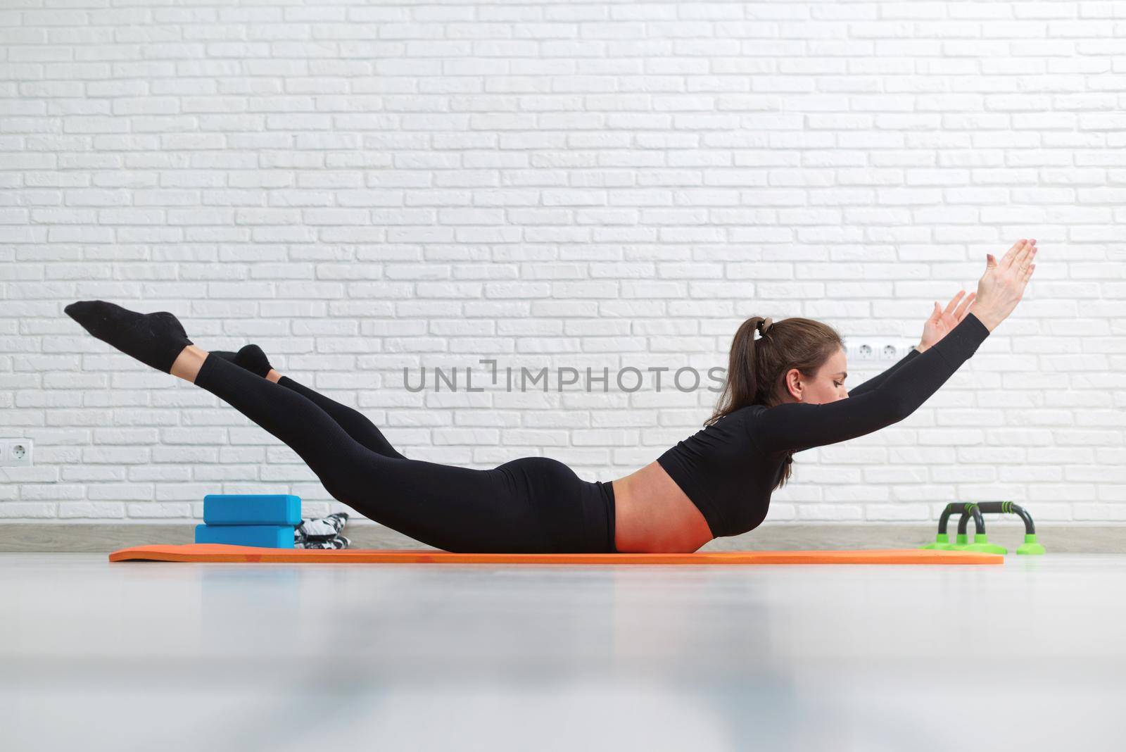 girl conducts a home workout stretching to strengthen her back