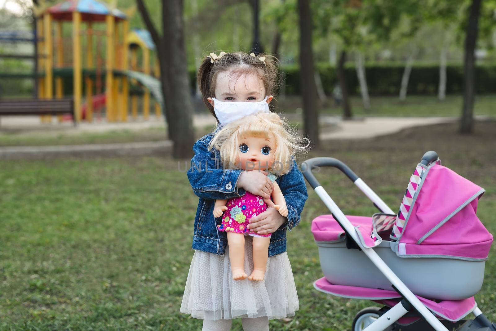 Little child girl hugging doll with wearing mask to against corona virus and air pollution pm2.5