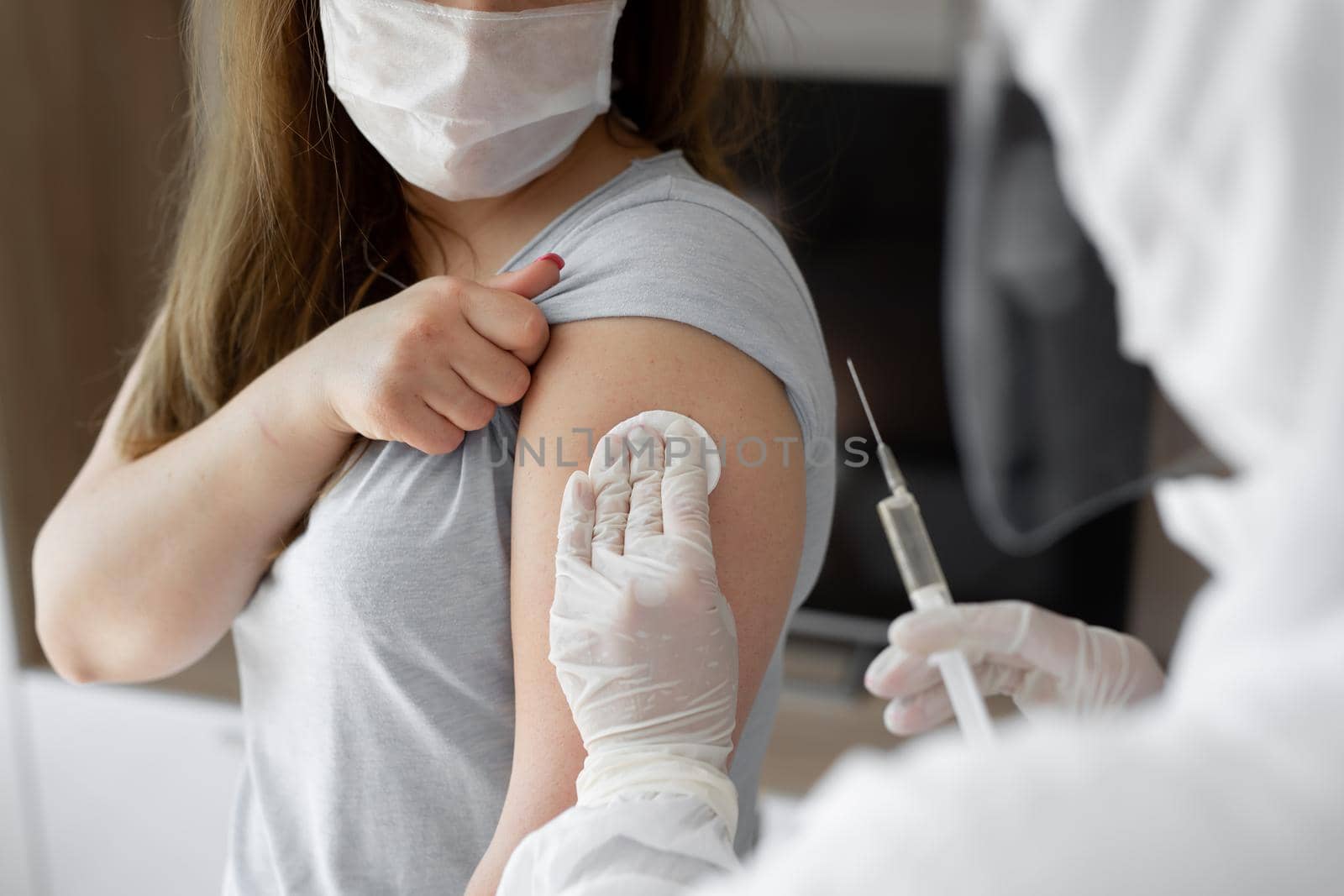 Doctor in personal protective suit or PPE inject vaccine shot to stimulating immunity of woman patient at risk of coronavirus infection. Coronavirus,covid-19 and vaccination concept.