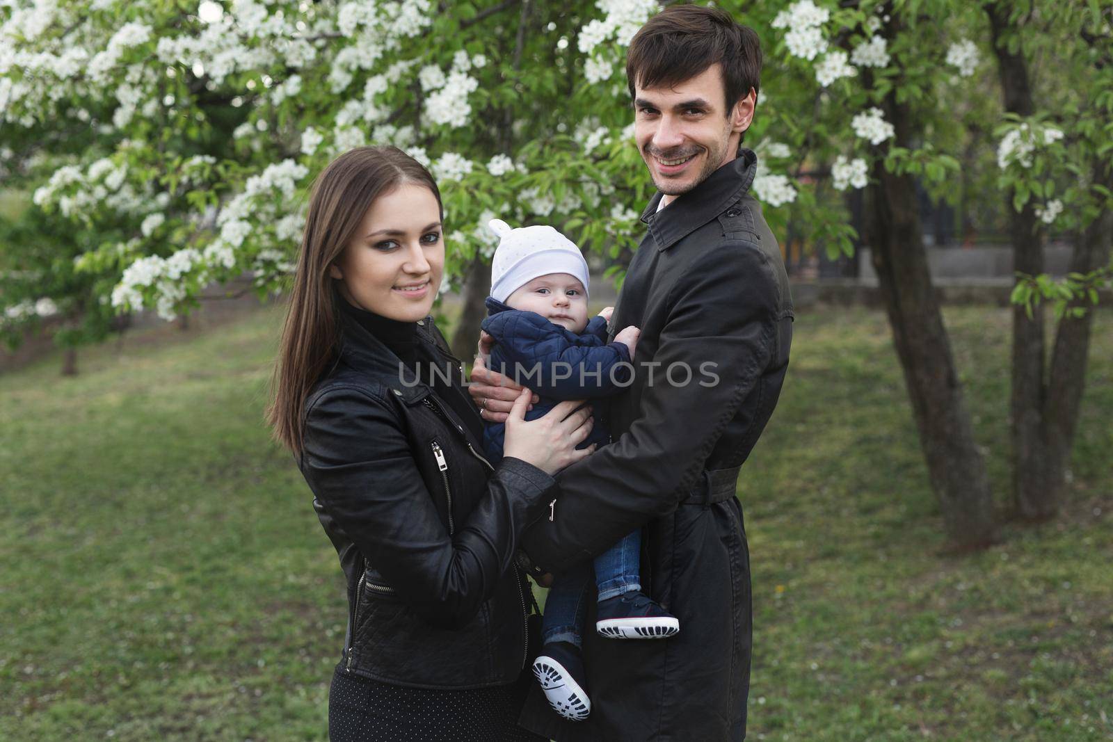 Beautiful smiling faces of people. A happy young family from three persons. by StudioPeace