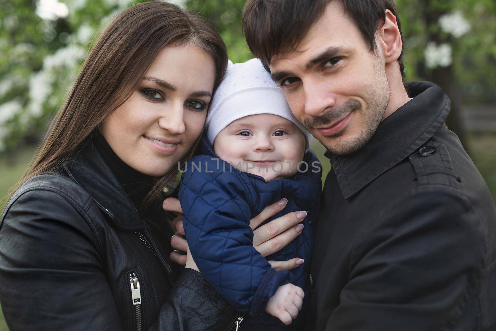 Beautiful smiling faces of people. A happy young family from three persons
