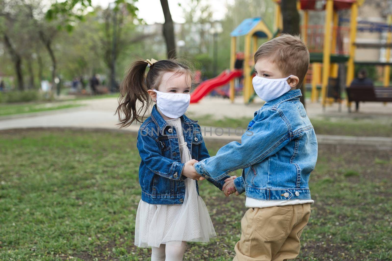Child boy and girl walking outdoors with face mask protection. Coronavirus, covid-19. by StudioPeace