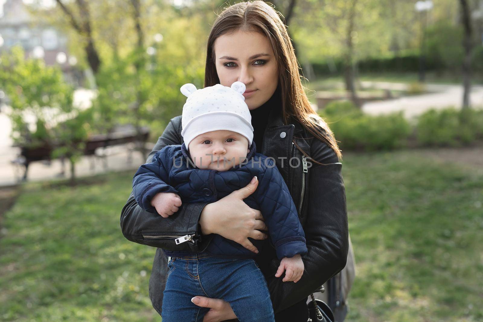 Mom and son with a small child are walking in a spring forest or park