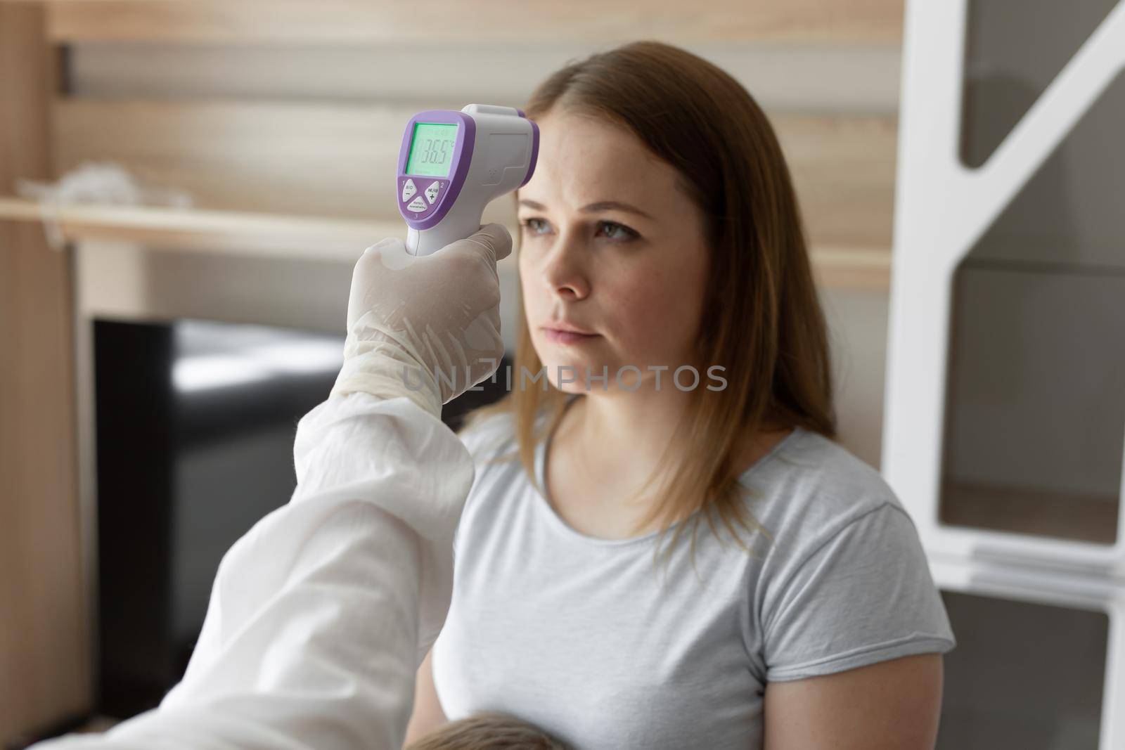 Doctor check patient body temperature using infrared forehead thermometer gun at home. Coronavirus, covid-19, Quarantine, high temperature. by StudioPeace