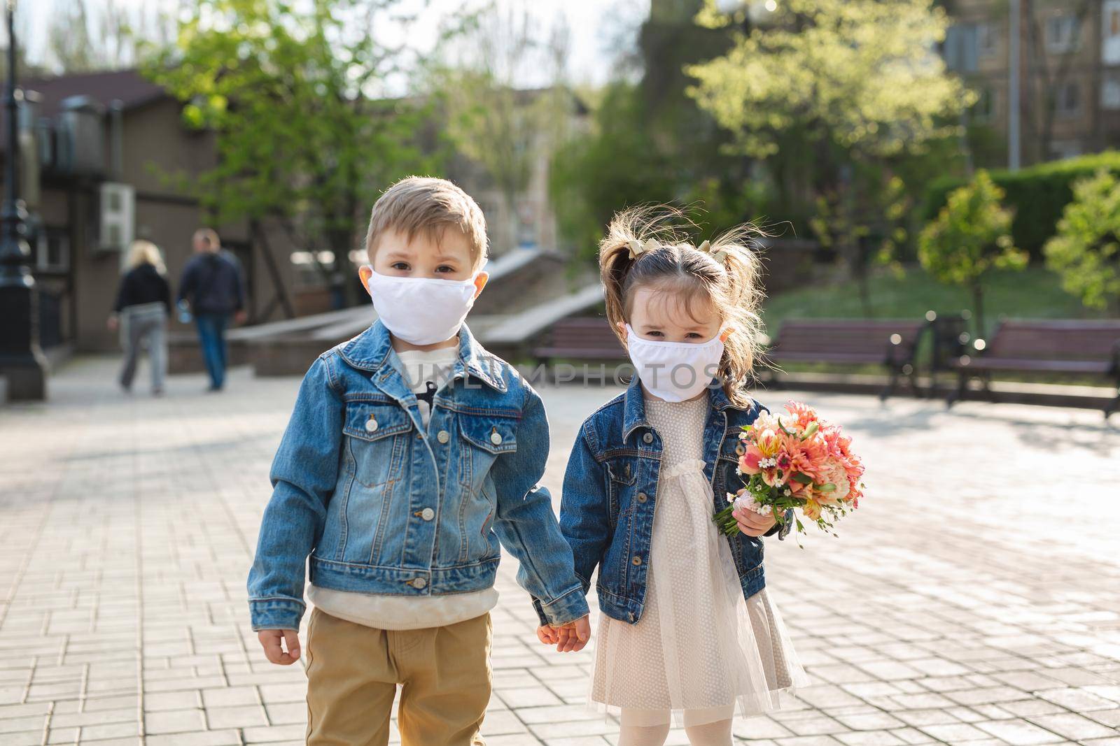 Child boy and girl walking outdoors with face mask protection. Coronavirus, covid-19. by StudioPeace