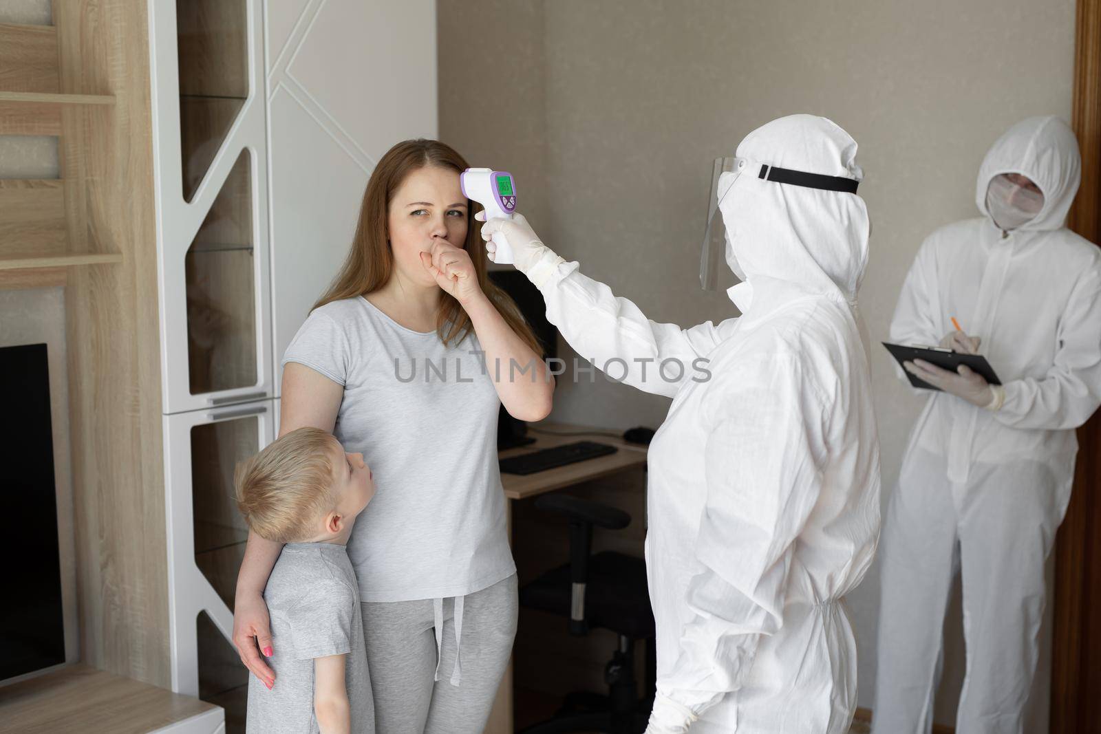 Doctor check patient body temperature using infrared forehead thermometer gun at home. Coronavirus, covid-19, high fever and cough by StudioPeace