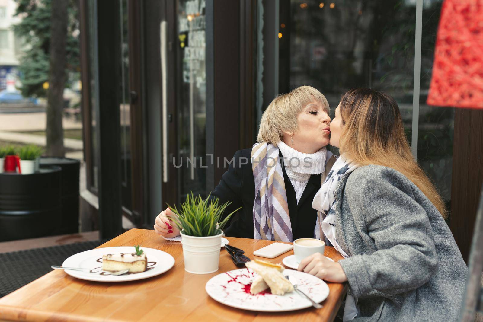 Mother and daughter love, emotions and a kiss in the coffee by StudioPeace