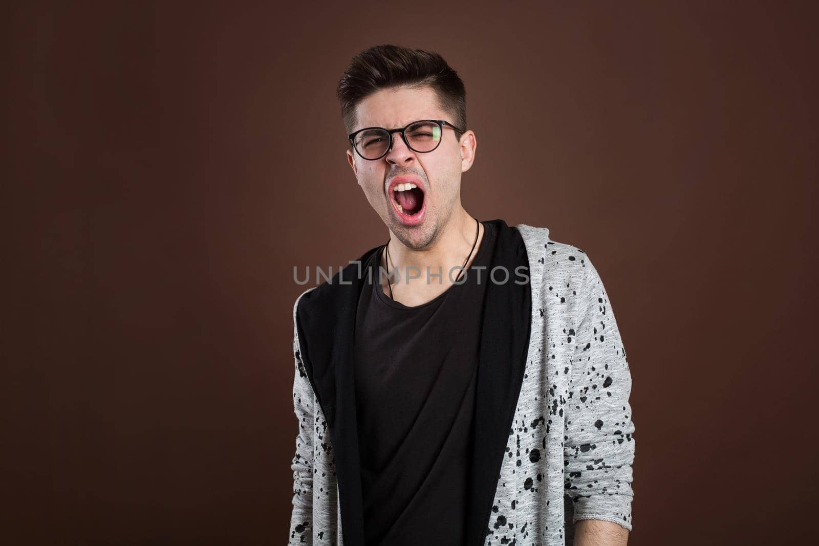 Portrait of a yawning man on a brown background. by StudioPeace