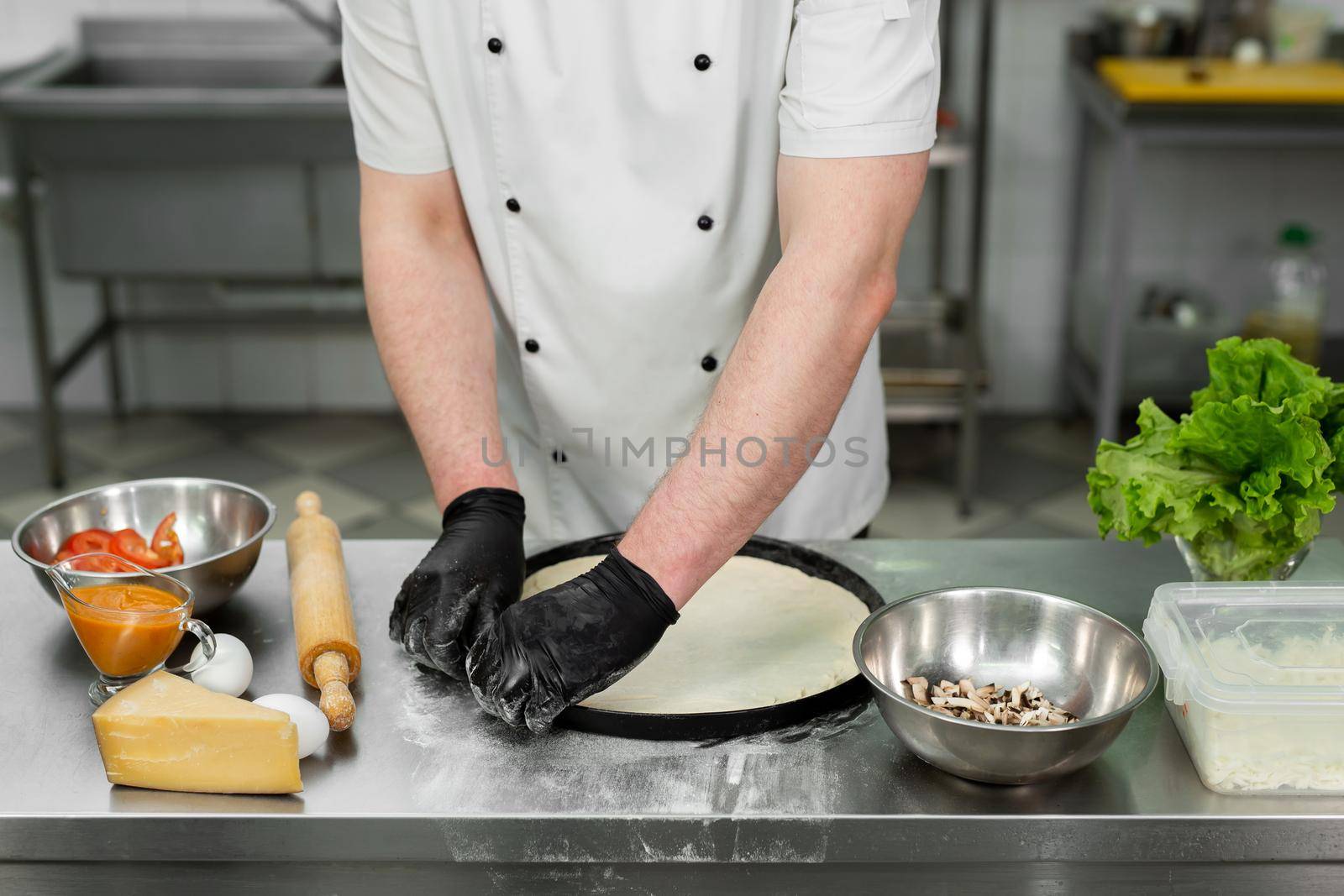 Chef is working in the kitchen with pizza dough