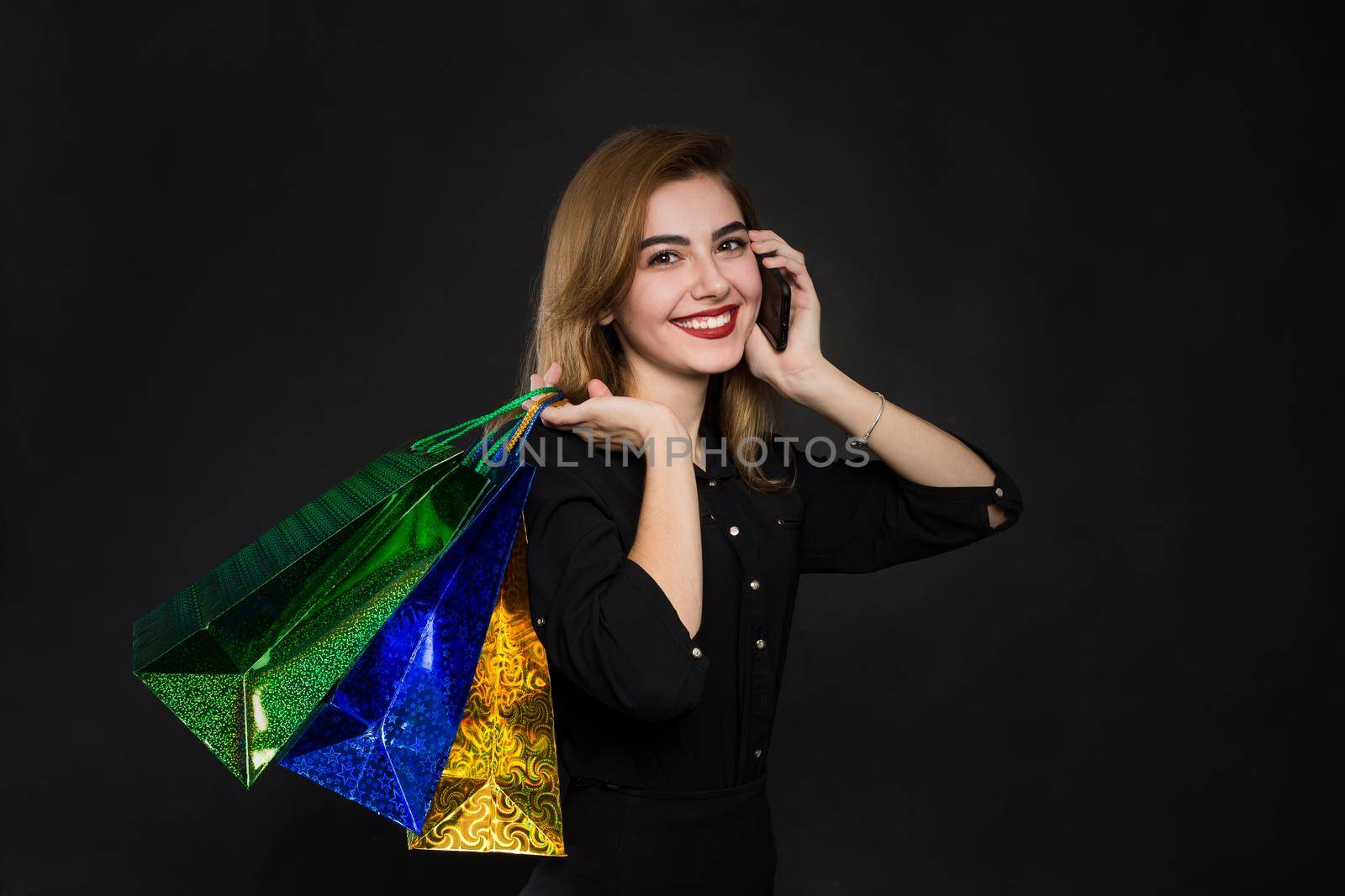young woman with packages, shopping, discounts on a brown background