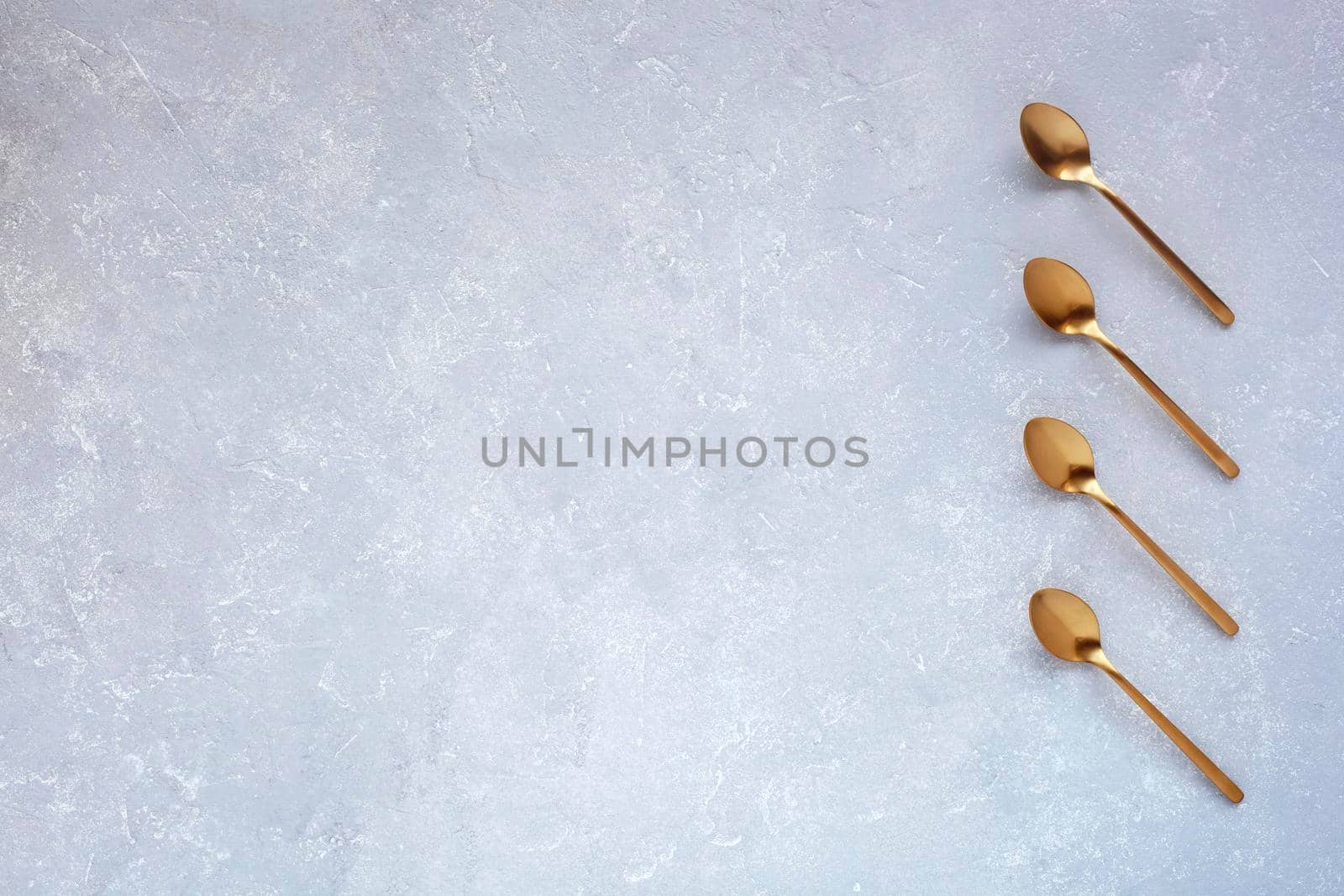 grey background with golden coffee spoons, top view, space for creating a list, plan, shedule