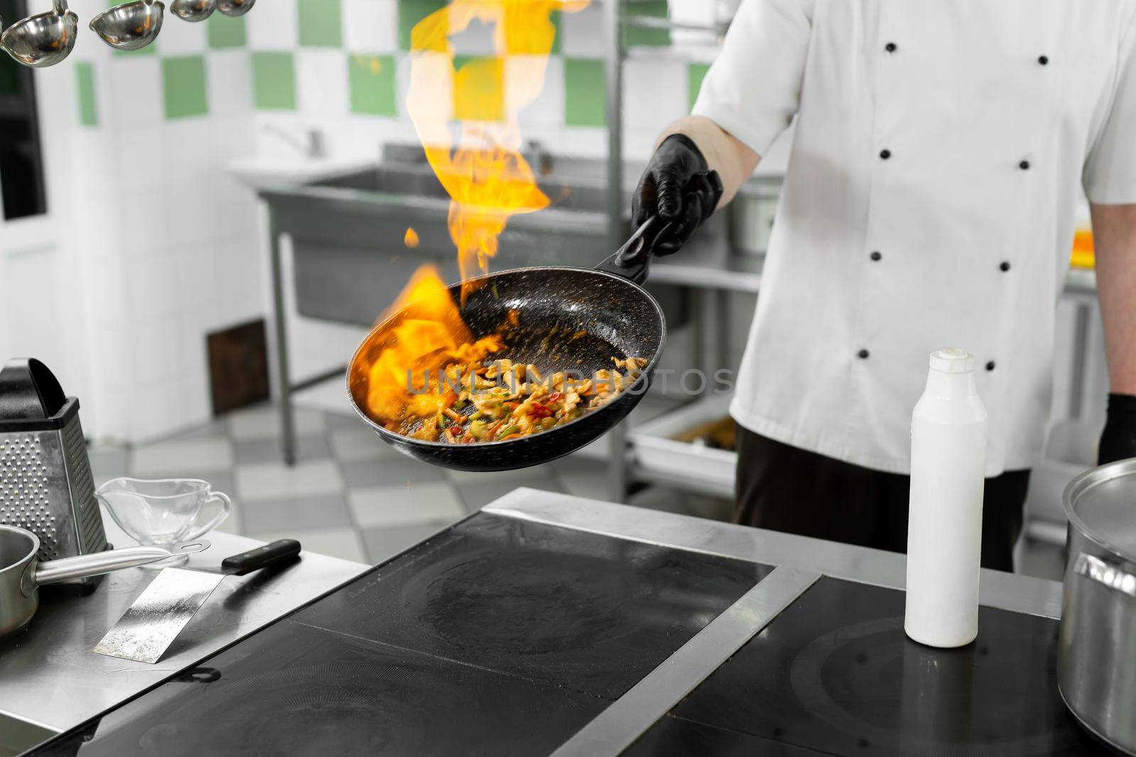 Modern kitchen. Cooks prepare meals on the stove in the kitchen of the restaurant or hotel. The fire in the kitchen